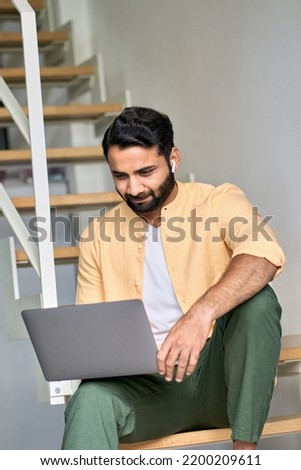 Indian man remote working on laptop device, using computer for virtual learning, surfing internet digital technology watching online web education webinar, having hybrid video call meeting from home.