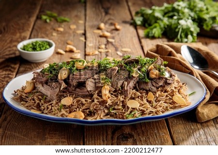 ouzi lamb or lamb pulao with nuts served in a dish side view isolared on wooden table Royalty-Free Stock Photo #2200212477