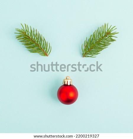 Face of a reindeer with a red bauble nose and fir antlers, merry christmas greeting card 