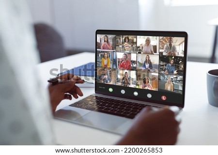 Composition of african american businesswoman having video call with colleagues in office. Global business and digital interface concept digitally generated image.