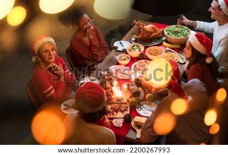 Overhead view on family sitting around christmas table with traditional Christmas roast Royalty-Free Stock Photo #2200267993