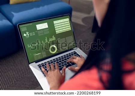 Composition of data processing on laptop over caucasian businesswoman in office. Global business and digital interface concept digitally generated image.