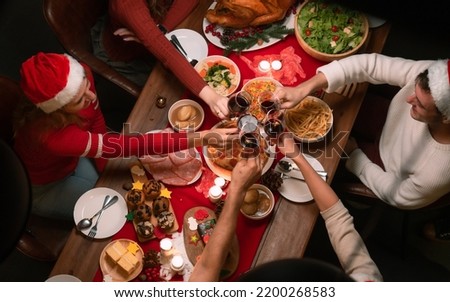 Overhead view on family sitting around christmas table with traditional Christmas roast Royalty-Free Stock Photo #2200268583