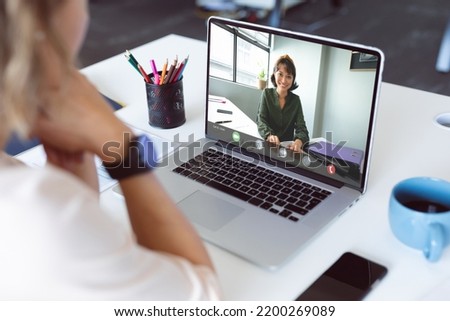 Composition of biracial businesswoman having video call with colleague. Global business and data processing concept digitally generated image.