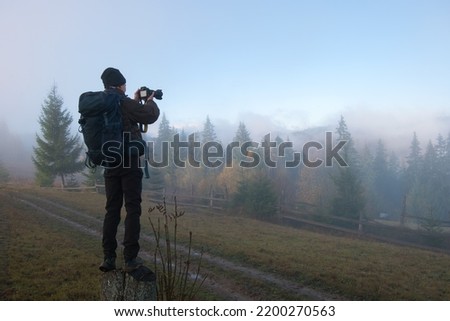 Photographer hiker taking picture of nature with digital camera
