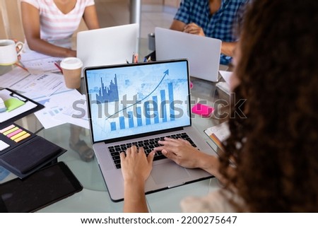 Caucasian businesswoman using laptop with data processing. Global business and digital interface concept, digital composite image.