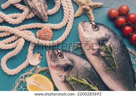 Fish arrangement with lemon top view Royalty-Free Stock Photo #2200283693