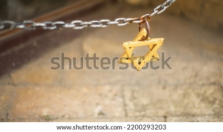 Star of David on a chain. Jews. Ghetto. Jerusalem. Wall. Copy space for text. Religious symbols. Signs.
