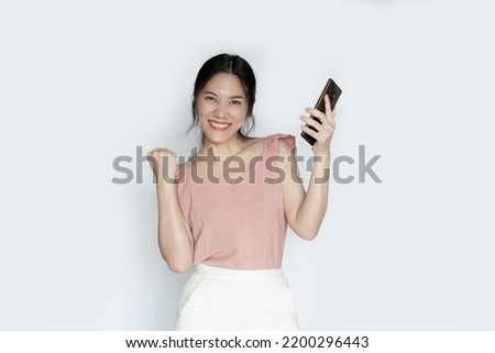 Asian beautiful woman is holding smartphone and smiling  with a happiness  for  shopping online or wining. 