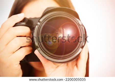 Photographer with professional camera on light background, closeup