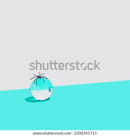 Abstract composition with skull reflected in a glass sphere. Turquoise and white Halloween background.