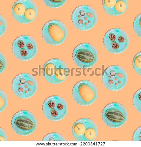 Retro Halloween pattern. Turquoise color plates with pumpkins, hazelnuts, pine cones and chestnut. Vintage aesthetic background.