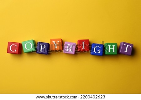 Plagiarism concept. Word Copyright made of color cubes on yellow background, top view Royalty-Free Stock Photo #2200402623