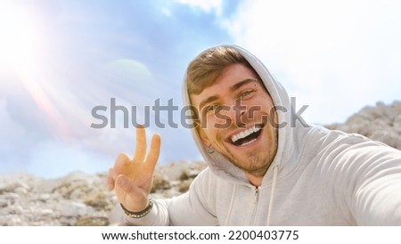 hiker young man portrait selfie on top of the mountain under the sun , happy hiking Caucasian handsome smiling 