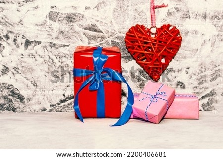 Red heart and gift box on grey wall background. Rattan work of heart shape