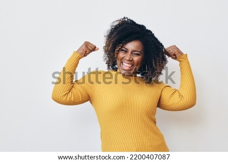 Cheerful strong woman flexing muscles against white background Royalty-Free Stock Photo #2200407087