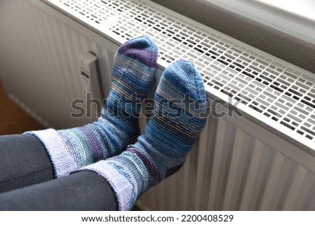 feet with thick socks on a heater