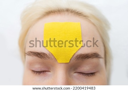 Facial tape, close-up of a girl's face with an anti-wrinkle cosmetology tape. Aesthetic taping of the face. Non-invasive anti-aging lifting method to reduce wrinkles Royalty-Free Stock Photo #2200419483