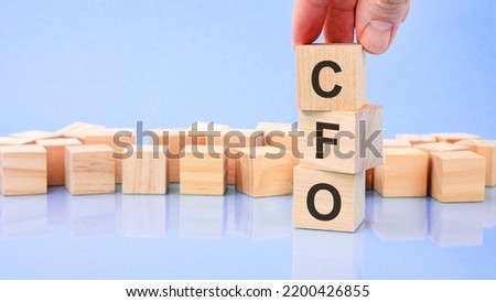 the text CFO is written on wooden cubes on a bright blue surface. Business concept. CFO - short for chief financial officer