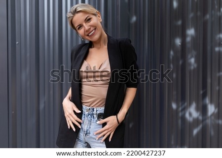 confident middle-aged woman against a gray wall