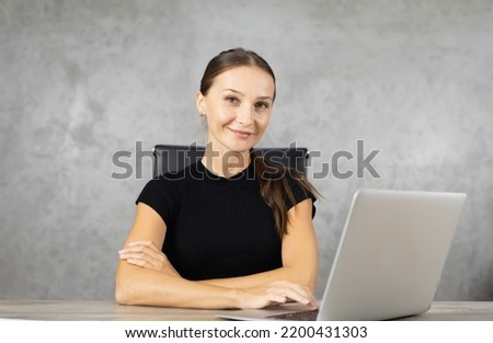 portrait of happy smiling pretty woman looks at camera, cross arm, use computer with copy space at background. pretty caucasian woman relax working business at home office Royalty-Free Stock Photo #2200431303