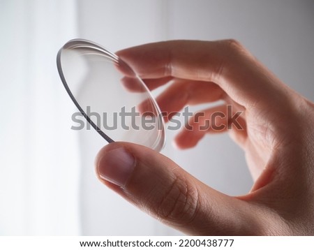 hand holding lens for eyeglass modern manufacturing in laboratory Royalty-Free Stock Photo #2200438777