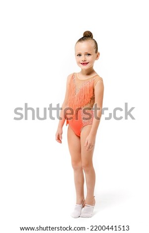 Small artistic gymnast acrobatics girl stay full length at studio isolated background in bright festive leotard