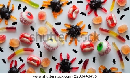 Close-up bright jelly candies,spiders,eyes,jaws,worms and bats,on white background,top view,flat lay,copy space.Decor concept for Halloween party,holiday treat,junk food.Pattern