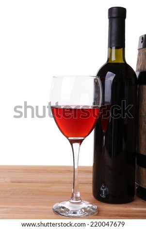 Wine in goblet and in bottle, grapes on wooden table isolated on white