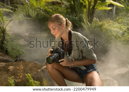 portrait of nice young woman is taking picture in the jungle