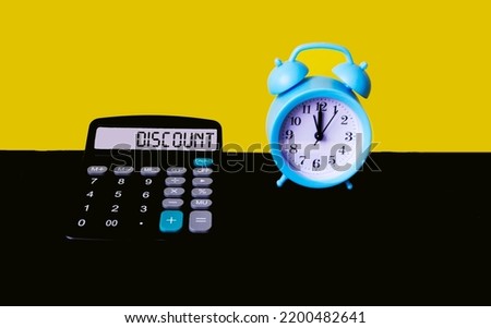 Discount word on calculator display screen on yellow and black background with clock. The concept of calculating discounts.