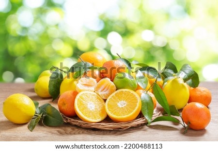 fresh citrus fruits with leaves on a wooden table Royalty-Free Stock Photo #2200488113