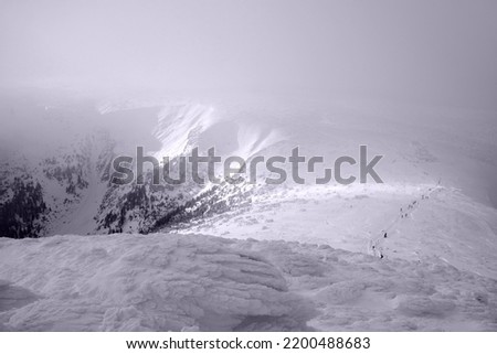 Winter mountain view with crowd of people walking on trail to Sniezka Mountain, Karkonosze Mountains (Giant Mountains), Poland