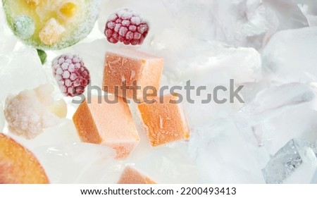 Closeup frozen chopped bricks vegetables (pumpkin) on ice. Stocks of food. View above.