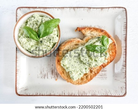 appetizer, delicious Greek or Cretan meze or paste spread on slice of toast bread on table. appetizer originates from Crete island, Greece. greek food made of cheese, garlic and basil, selective focus Royalty-Free Stock Photo #2200502201