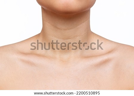 Cropped shot of young woman with wrinkles, age-related changes, rings of Venus, goosebumps on her neck isolated on a white background. Lines on the neck. Skin care