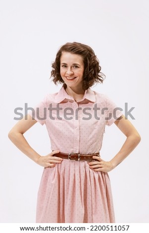 Portrait of young beautiful woman posing, looking at camera and smiling isolated on white background. Happy wife. Concept of beauty, retro style, fashion, elegance, 60s, 70s, family. Copy space for ad Royalty-Free Stock Photo #2200511057