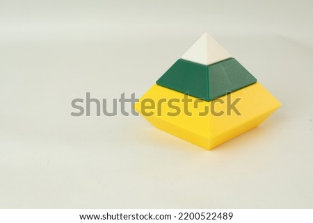 A big pyramid build from colored wooden rings on a vertical stick, isolated on a white background. Toys for babies and toddlers to joyfully learn mechanical skills and colors