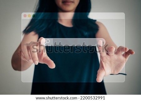 Data researching and searching engine optimization concept. Transparent window with blank search bar display in front of Asian woman, touching the visual screen for reviewing information on internet.