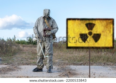 military chemical reconnaissance measures the level of radiation, Old textural Sign of radiation hazard, against the background of infected nature. Royalty-Free Stock Photo #2200533843