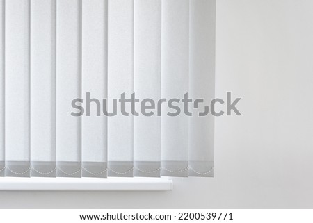row of grey vertical blinds cover sunlight from window in office. part of white and new fabric jalousie in modern apartment Royalty-Free Stock Photo #2200539771