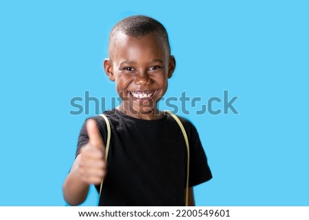 young black guy on blue background with thumbs up because something good happened