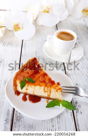 Cheese cake, orchids and cup of coffee on wooden background