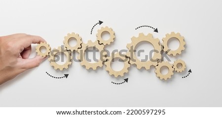 Business process and workflow automation with flowchart. Hand holding wooden cog flowing process management on white background