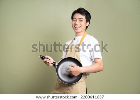 man holding a pan on the background Royalty-Free Stock Photo #2200611637