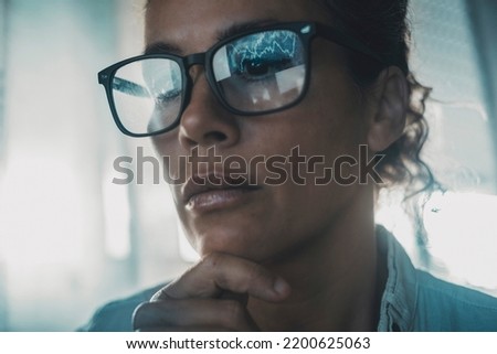 Technology concept people portrait with digital charts reflected on eyewear. One woman in business online modern activity looking a display with reflection on glasses. Concept of businesswoman alone