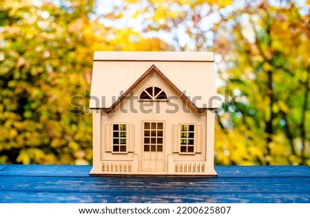 House symbol on a background of yellow autumn leaves
