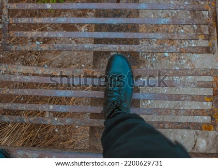 Army boot on rusty stairs