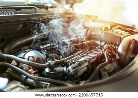 car engine overheating close up. vehicle engine in smoke. smoke or steam from a vehicle engine Royalty-Free Stock Photo #2200657715