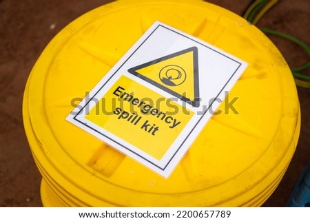 "Emergency spill kit" yellow plastic containment box. Safety sign and symbol at industrial equipment.  Royalty-Free Stock Photo #2200657789